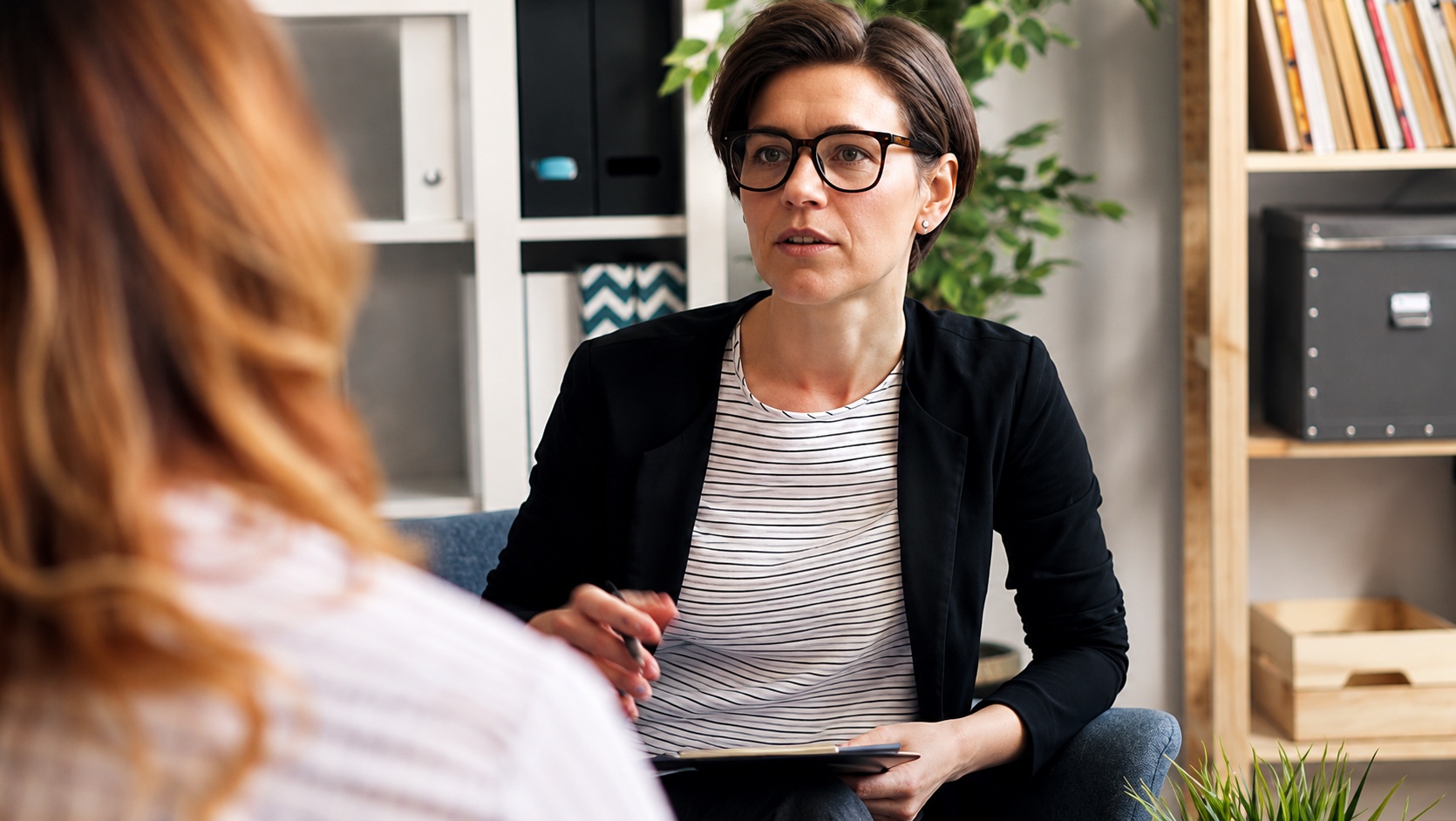 A therapist speaking with a client in a comfortable office.