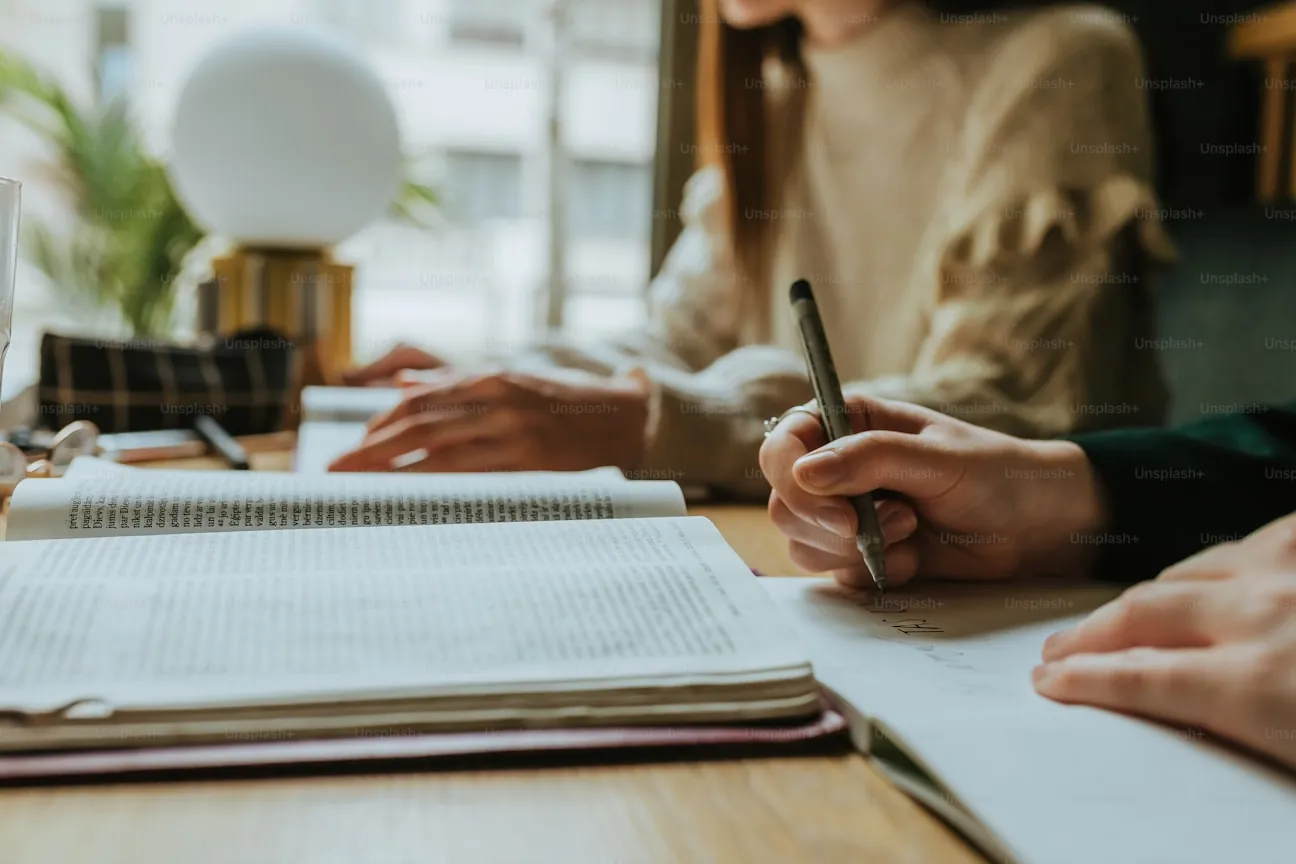 People reviewing research notes and books at a table.