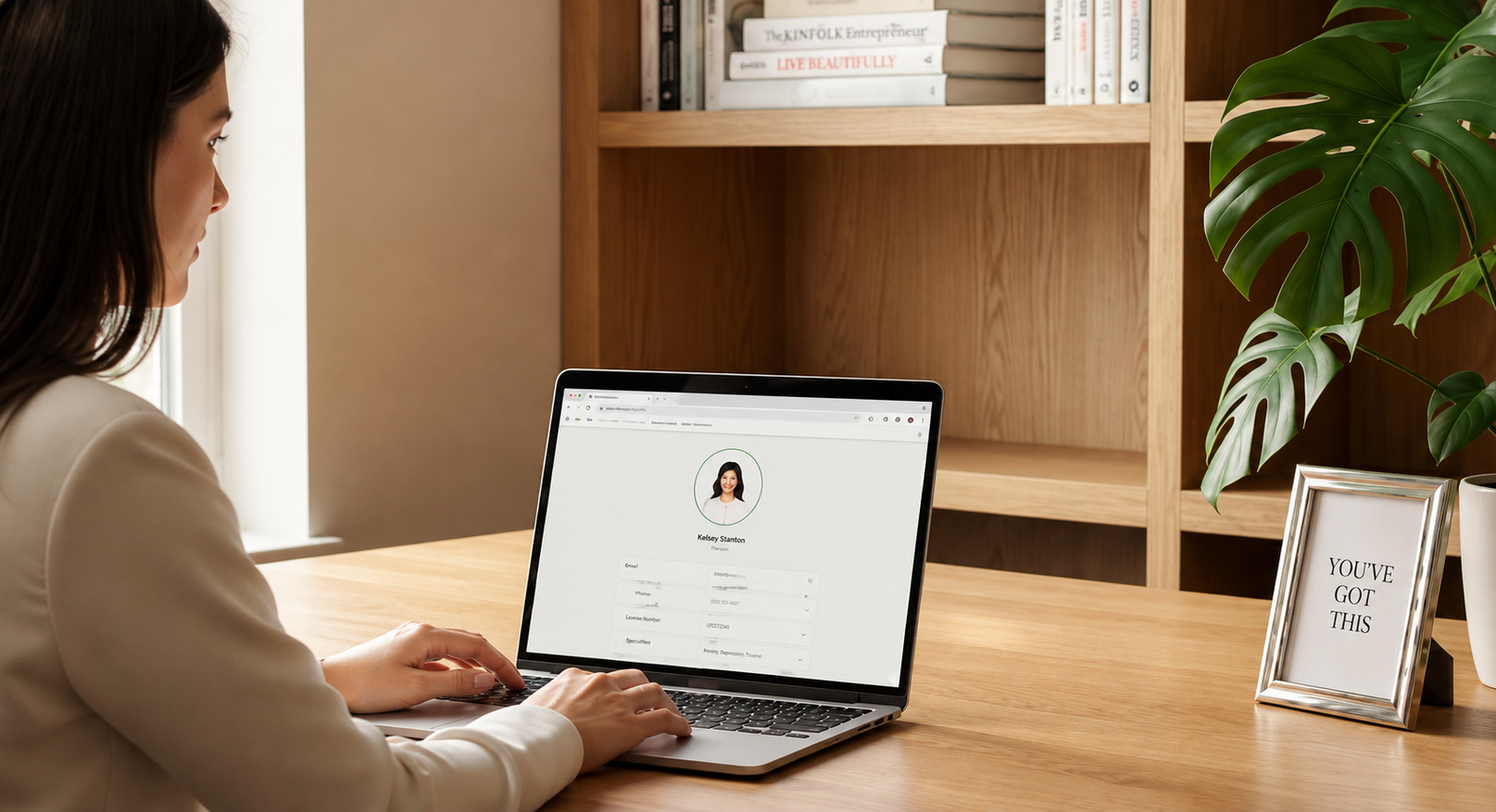 A therapist building a profile on a laptop at a desk.